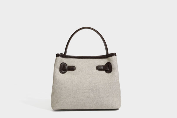 Small structured beige canvas top-handle bag with dark brown leather-look trim, silver turn-lock hardware, and detachable