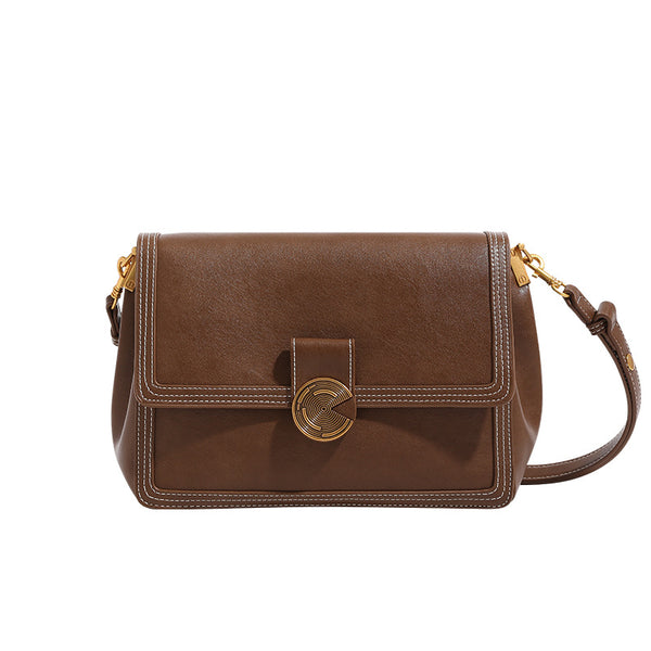 Structured flap shoulder bag with gold-tone circular turn-lock closure, white contrast stitching, and adjustable strap