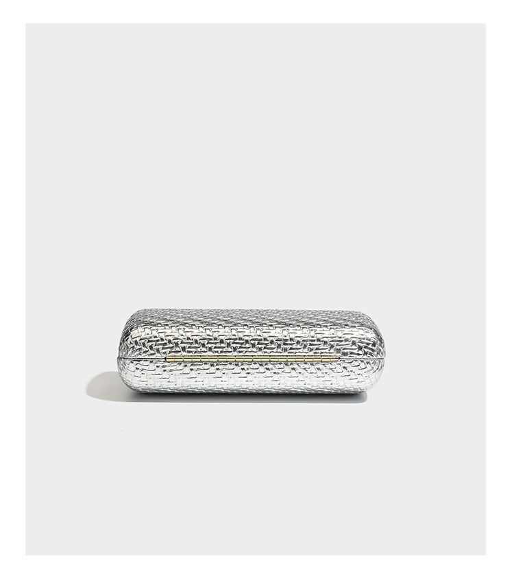 Small structured metallic woven-texture box clutch bag with jeweled kiss-lock dome clasp and slim gold chain strap, detail
