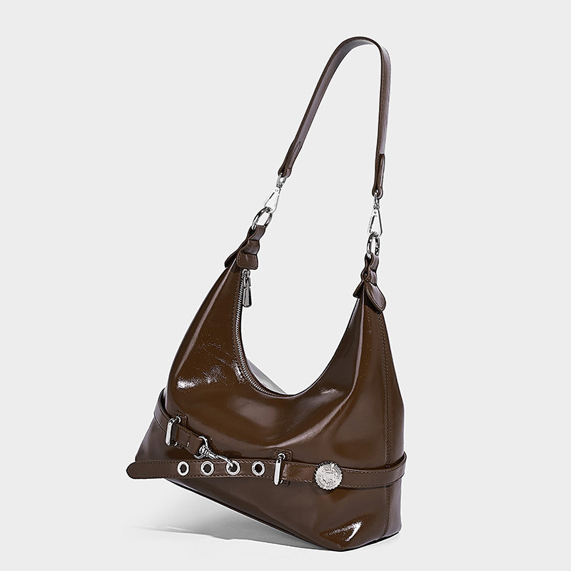 Glossy black slouchy hobo shoulder bag with silver-tone hardware, belt-style grommet strap at base, and long adjustable