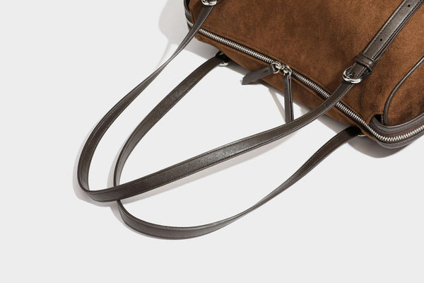 Large brown suede-finish barrel shoulder bag with dark leather-look trim, silver-tone zippers, dual top handles, and long