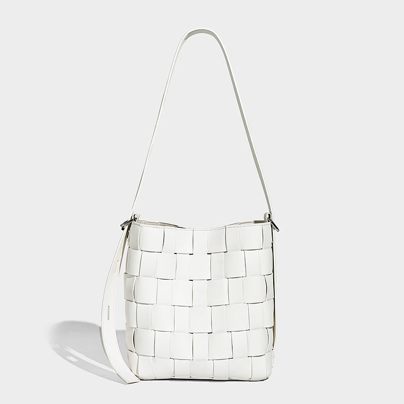 Hand-woven black-and-white checkerboard bucket bag with smooth black trim, silver-tone ring hardware, and adjustable