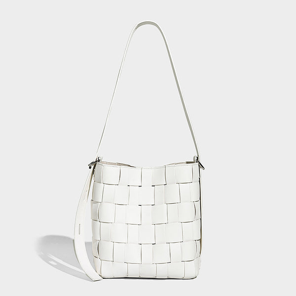 Hand-woven black-and-white checkerboard bucket bag with smooth black trim, silver-tone ring hardware, and adjustable