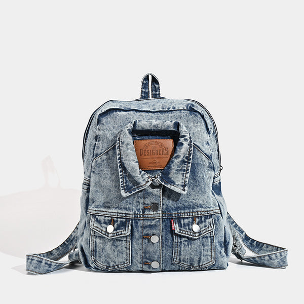 Vintage wash dark indigo denim backpack with jacket collar detail, snap buttons, patch pockets, and leather-look label