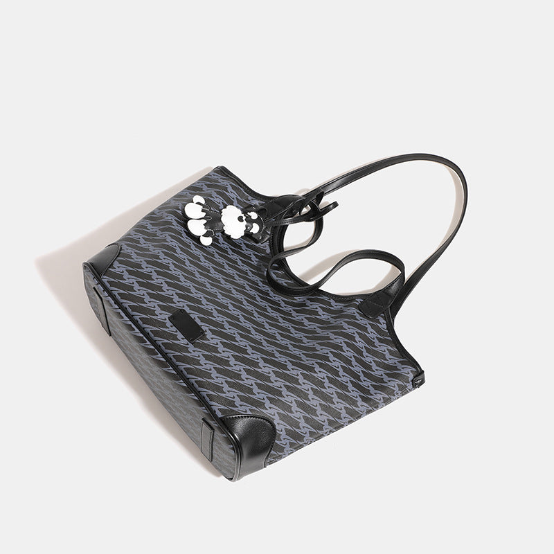 Large black monogram tote bag with tonal grey repeat print, leather-look trim, and black-and-white schnauzer bag charm