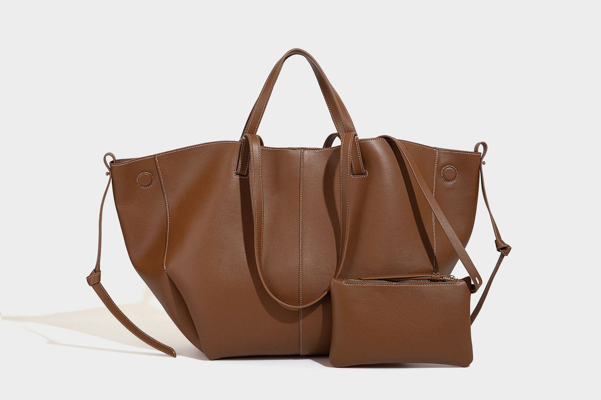 Große, formstabile trapezförmige Tote-Bag aus braunem Lederimitat mit genarbter Oberfläche, zwei Tragegriffen und seitlichen Bindebändern, Detail