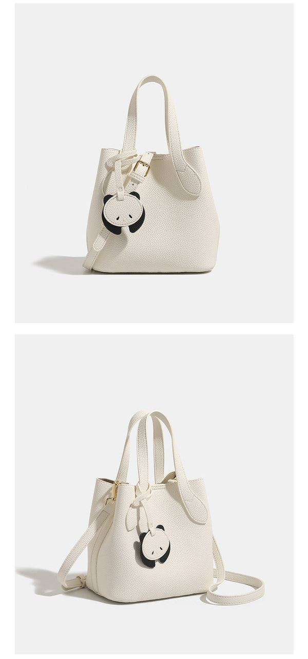 Pebbled leather-look bucket tote with elephant charm pendant, dual top handles, and detachable shoulder strap, detail view 9