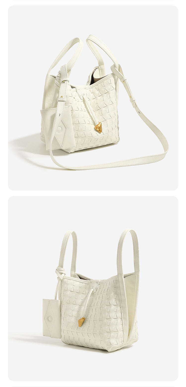 Cremefarbene Bucket Bag mit geometrischem Dreiecksrelief, schmalem Schulterriemen, goldfarbenem Dreiecksanhänger und abnehmbarer Mini-Tasche mit Druckknopfverschluss