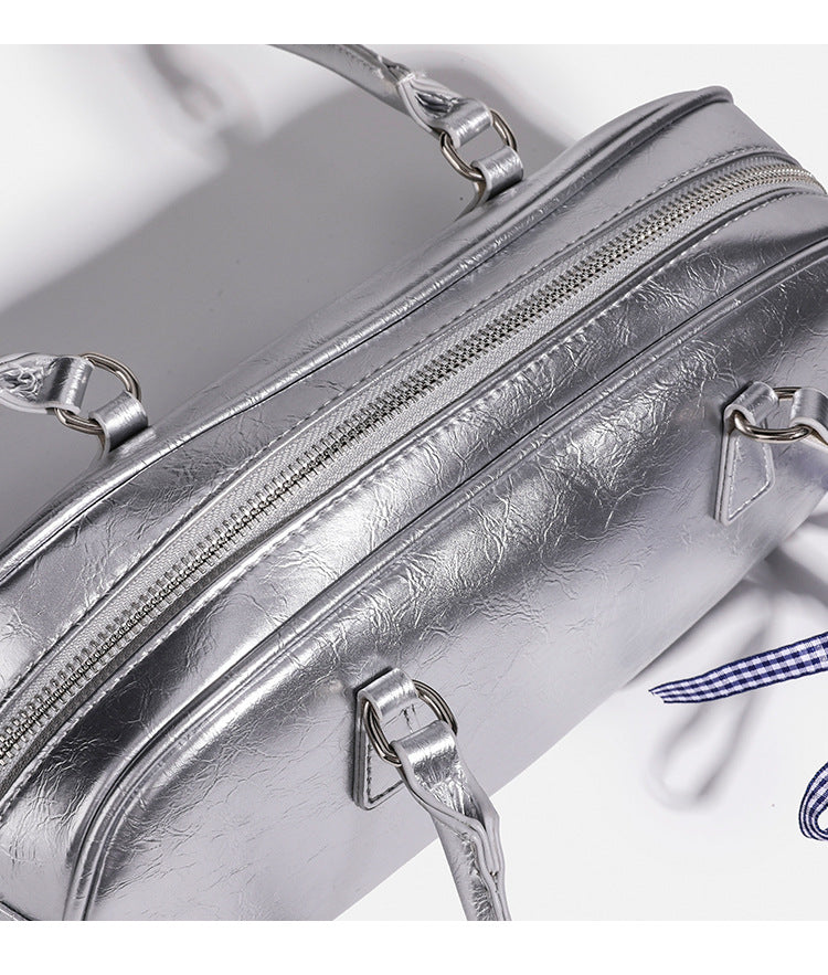Rounded rectangular shoulder bag with glossy crinkled finish, dual long handles, top zip closure, and gingham ribbon bow