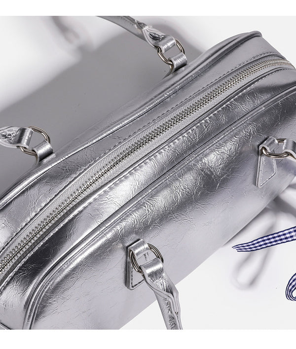 Rounded rectangular shoulder bag with glossy crinkled finish, dual long handles, top zip closure, and gingham ribbon bow