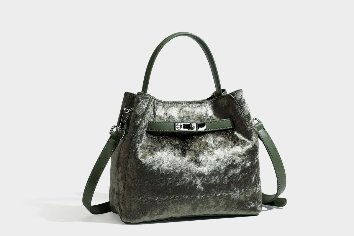 Small structured bucket satchel in embossed velvet-texture fabric with silver turn-lock hardware, rounded top handle, and