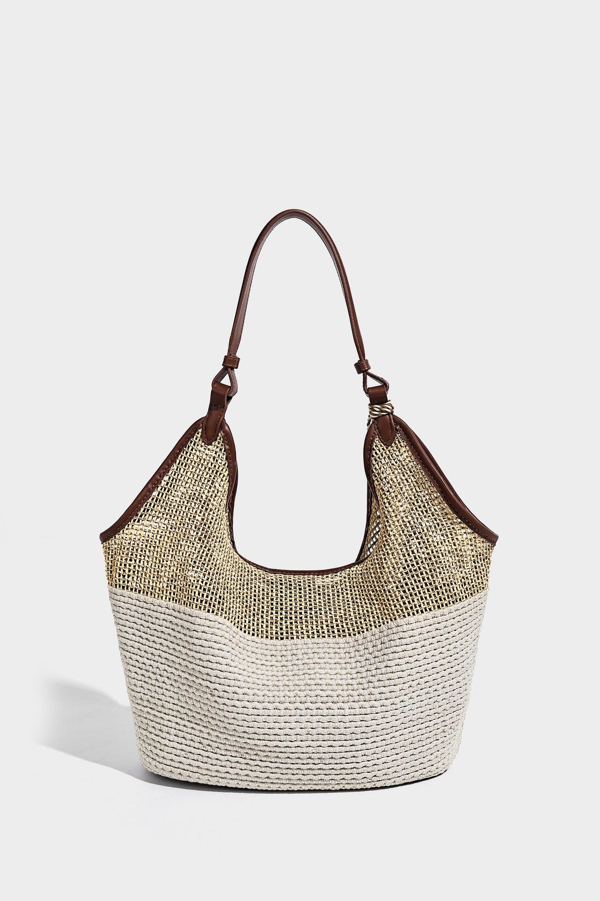 Two-tone beige and cream woven straw hobo shoulder bag with brown leather-look trim, long shoulder strap, and tassel-bead