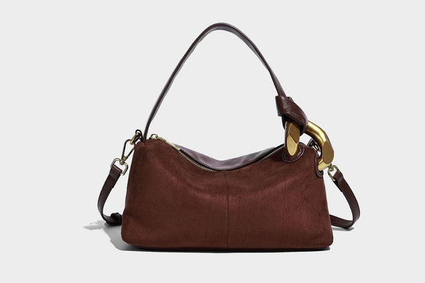 Kompakte Boston-Schultertasche in warmem Braun in Wildlederoptik mit glattem dunkelbraunem Besatz, übergroßen goldfarbenen Ringelementen und Reißverschluss oben
