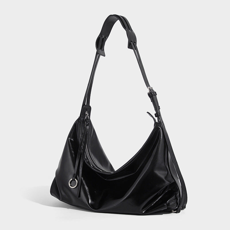 Glossy black slouchy hobo shoulder bag with zip closure, silver-tone ring hardware, and adjustable crossbody strap, front