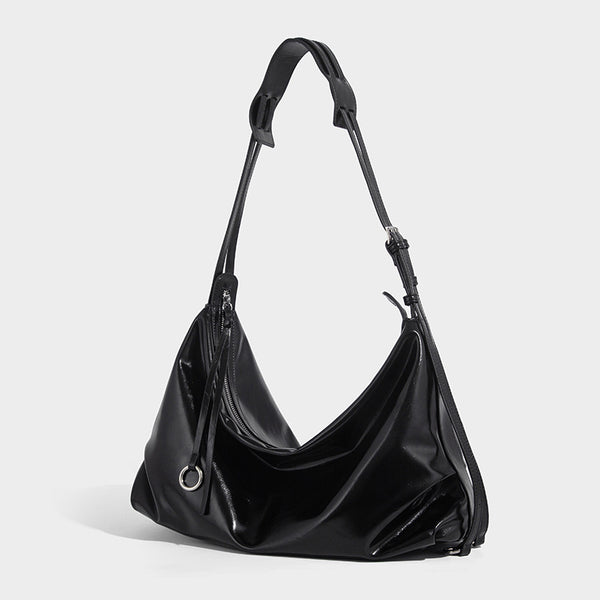 Glossy black slouchy hobo shoulder bag with zip closure, silver-tone ring hardware, and adjustable crossbody strap, front