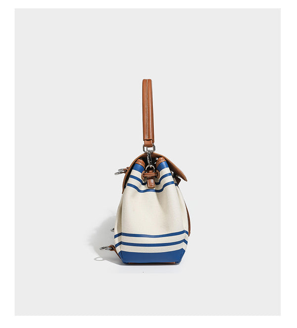 Cream canvas bucket bag with blue horizontal stripes, tan leather-look flap and trim, drawstring closure, silver-tone, detail
