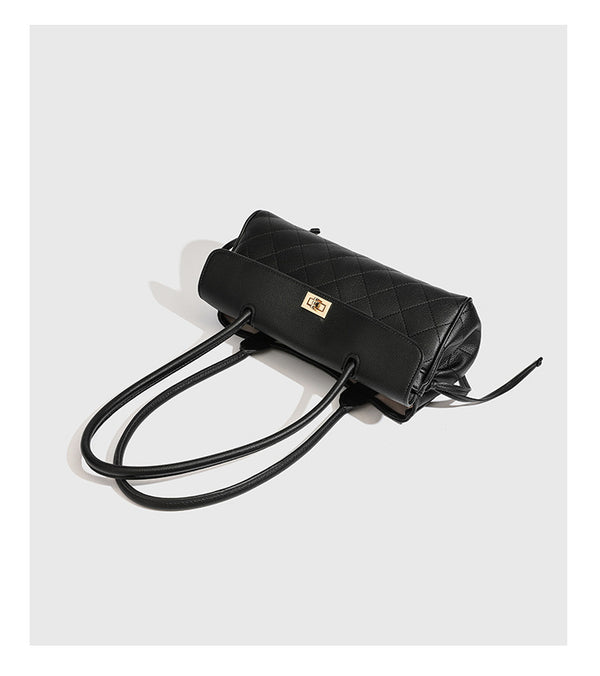 Structured black diamond-quilted shoulder bag with gold-tone turn-lock flap closure and dual round shoulder straps, detail