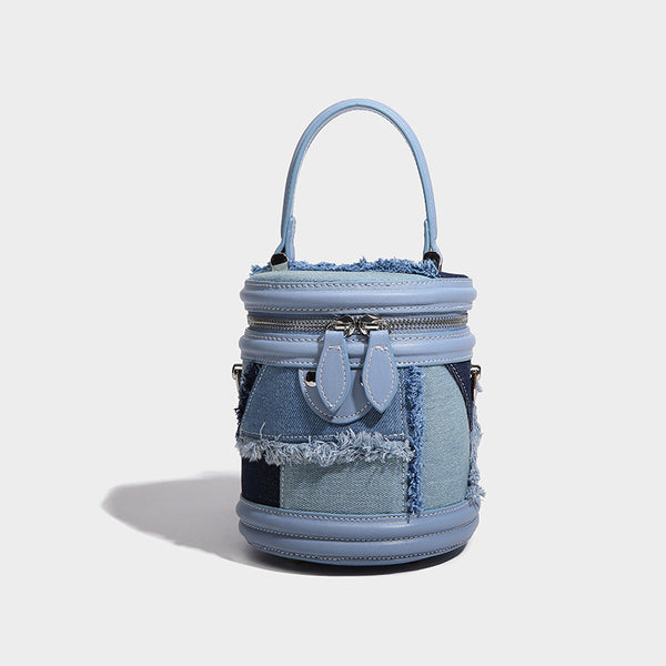 Mini cylindrical barrel bucket bag in denim patchwork with frayed edges, smooth leather-look trim, zip-around top closure