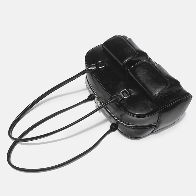 Structured glossy leather-look bowling shoulder bag with two front flap pockets, top zip closure, and long double shoulder