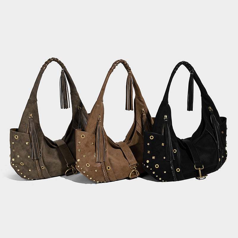 Slouchy crescent hobo bag in matte brown suede-like finish with gold-tone studs, grommets, braided top handle, tassel side