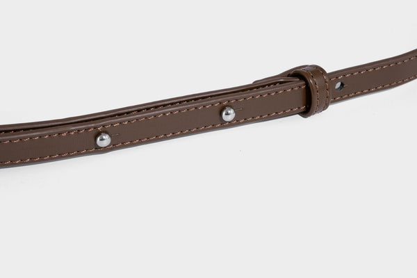 Small structured saddle bag with glossy leather-look finish, angular flap front, silver-tone metal clasp, and slim