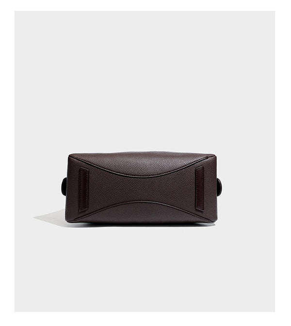 Structured trapezoid shoulder bag in dark brown pebbled leather-look finish with slim double straps, top zip closure, side