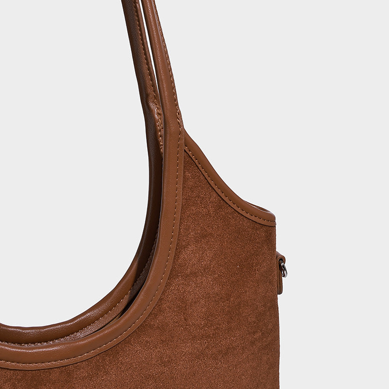 Warme mittelbraune Tote-Bag in matter Wildlederoptik mit langen Henkeln, geprägtem Logo-Detail, silberfarbenen Beschlägen und passendem, Detailansicht
