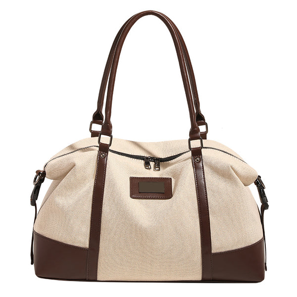 Large cream canvas tote bag with dark leather-look trim, dual top handles, and detachable shoulder strap, detail view 5