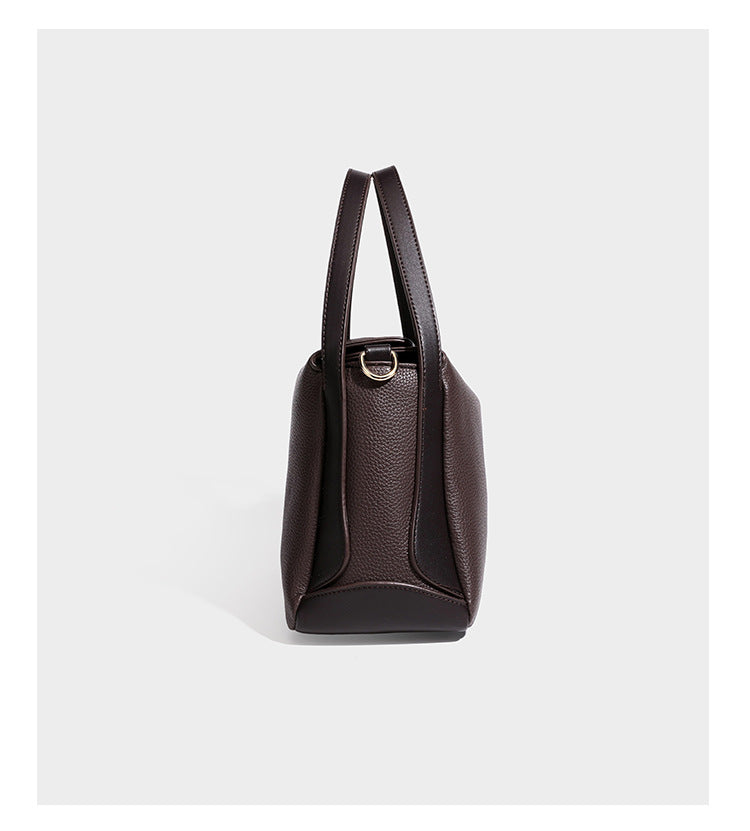 Structured pebbled leather-look shoulder bag with flap top, gold-tone emblem hardware, dual top handles, and detachable