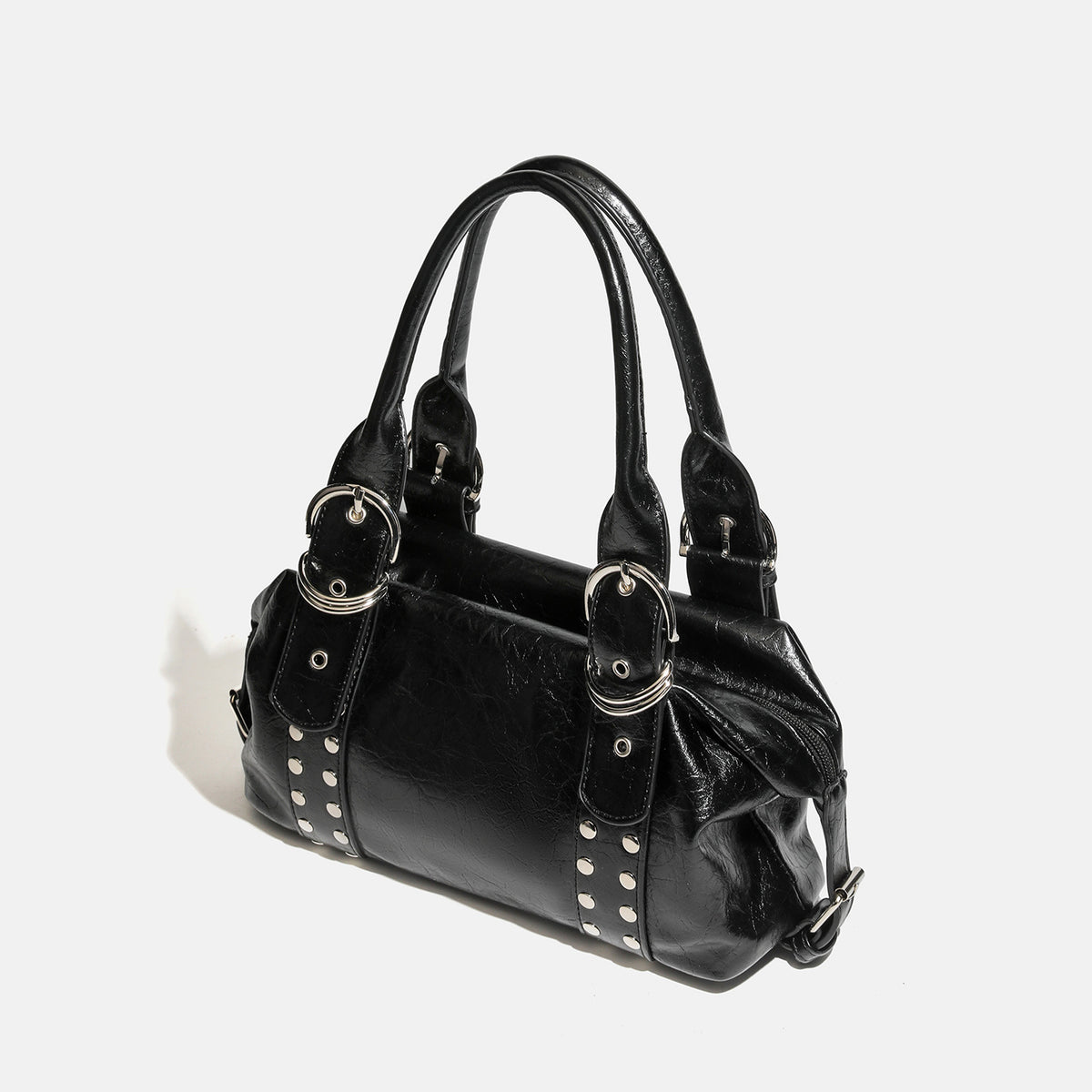 Compact black glossy leather-look satchel bag with silver-tone rivets, buckle hardware, and dual padded top handles, detail