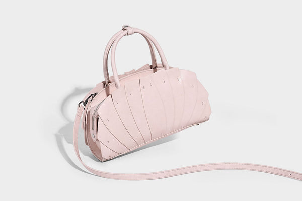 Structured dome satchel with fan-pleated leather-look exterior, dual top handles, and detachable shoulder strap, detail view