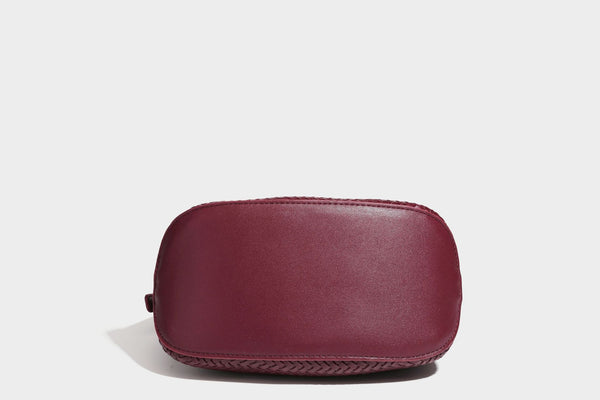 Small woven-look leather-look flap shoulder hobo bag in burgundy with silver-tone hardware and decorative tassel charm