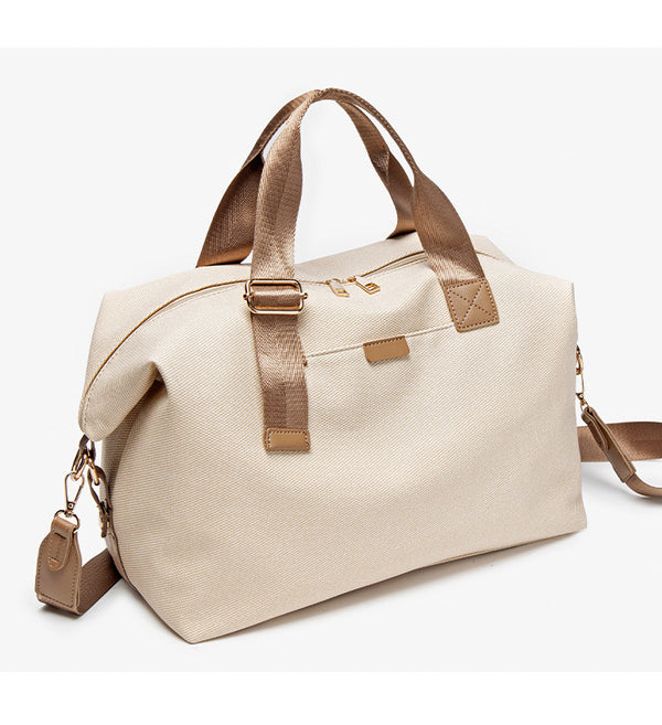 Structured woven duffel bag with dual tan webbing handles, detachable shoulder strap, top zip closure, and gold-tone