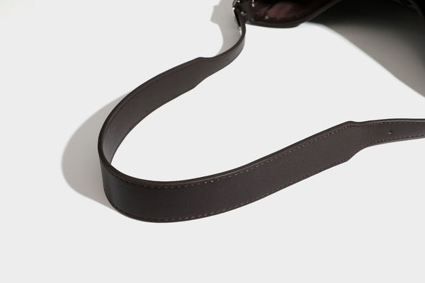 Schwarz-weiß karierte Hobo-Schultertasche aus gewebtem Material mit dunkelbrauner Einfassung in Lederoptik, Kordelzugverschluss und langem, verstellbarem