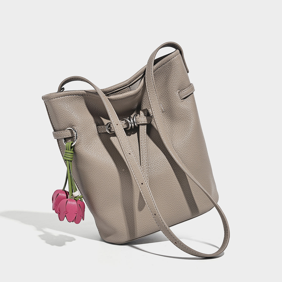 Small pebbled leather-look bucket bag with front drawstring toggle hardware and long adjustable shoulder strap, detail view 4