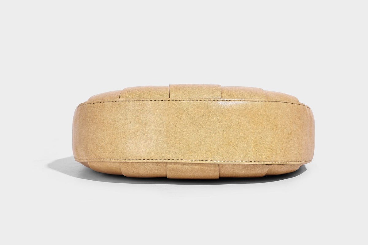 Crescent half-moon shoulder bag with vertical panel seaming, matte-satin leather-look finish, and adjustable gold-tone