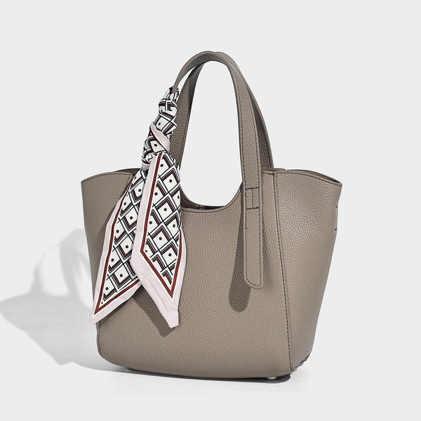 Structured pebbled leather-look tote bag with detachable scarf tie, dual top handles, and adjustable crossbody strap, front