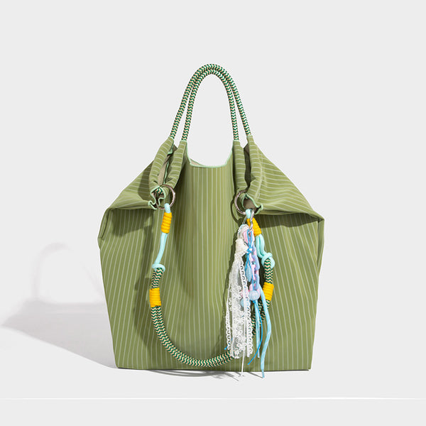 Slouchy pinstripe tote bag with braided rope handles, metal ring hardware, and colorful knotted rope charm, detail view 10