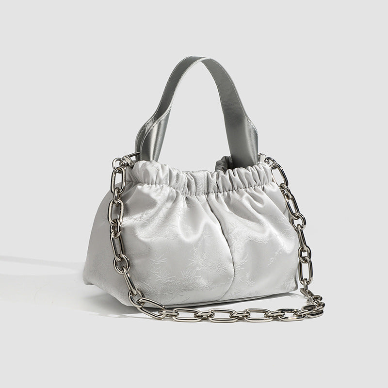 Kleine geraffte Cloud-Tasche mit Satin-Finish, elastischem Kordelzugverschluss, kurzem Tragegriff und markantem silberfarbenem Kettenriemen