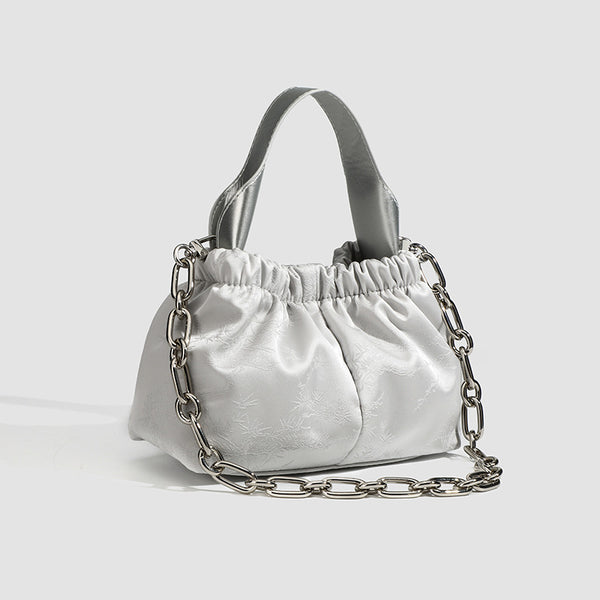 Small ruched satin-finish cloud bag with elasticized drawstring top, short top handle, and chunky silver-tone chain strap
