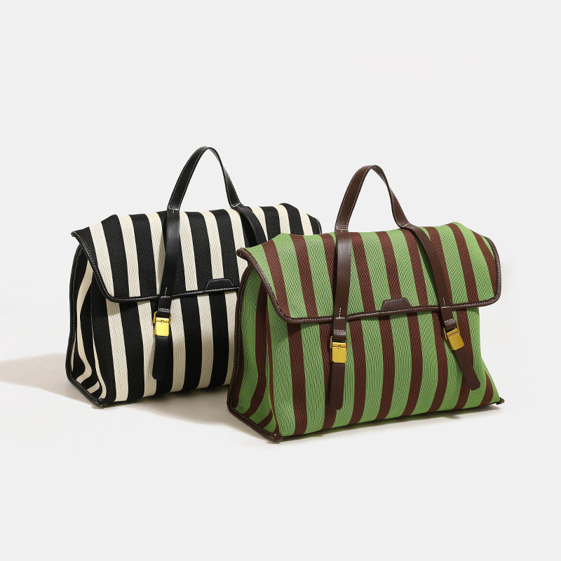 Structured striped canvas convertible satchel bag with leather-look trim, gold-tone buckle hardware, and backpack straps