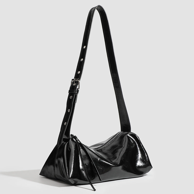 Black glossy leather-look slouchy shoulder bag with gathered top, zip tassel closure, and long adjustable silver-buckle