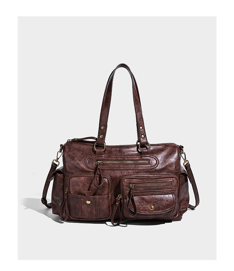 Distressed leather-look vintage satchel shoulder bag with multiple front zip pockets, dual top handles, and brass-tone