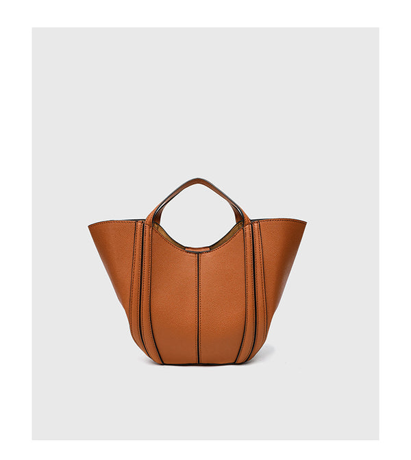 Structured open-top tote bag in tan brown pebbled leather-look finish with vertical seam accents, black edge piping, curved