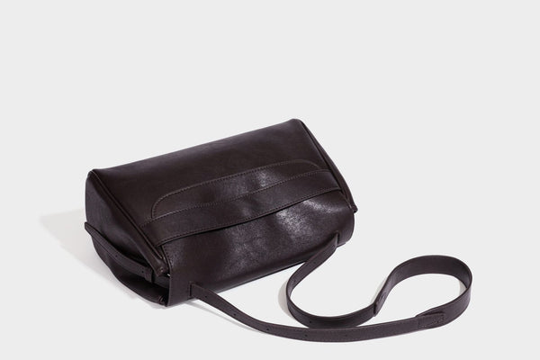Formstabile rechteckige Schultertasche in Dunkelbraun mit Lederoptik, Überschlag und mehrlagigem Frontdetail sowie langem verstellbarem Riemen, Detail