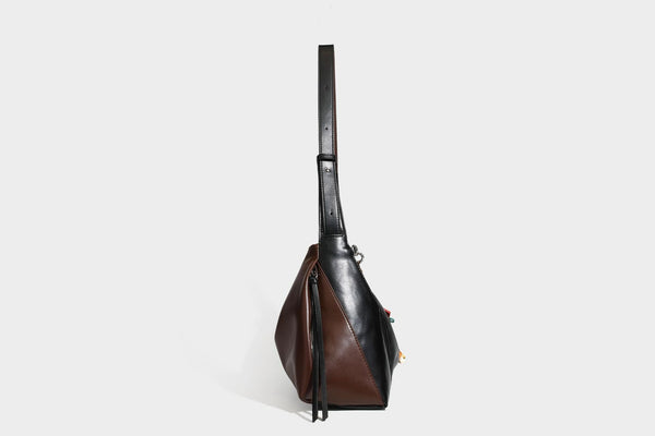 Two-tone black and brown leather-look slouchy shoulder bag with beaded tassel charm and silver-tone hardware, detail view 25