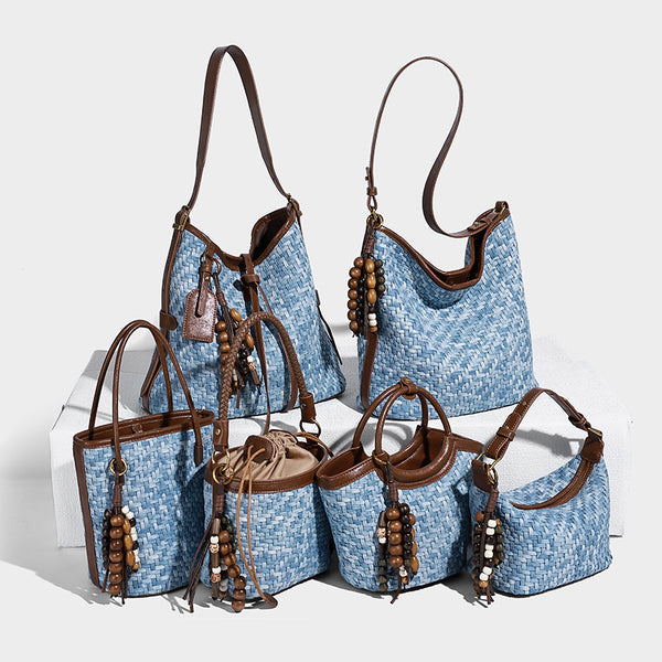 Light blue woven bucket bag with brown leather-look trim, gold-tone hardware, adjustable shoulder strap, and decorative bead