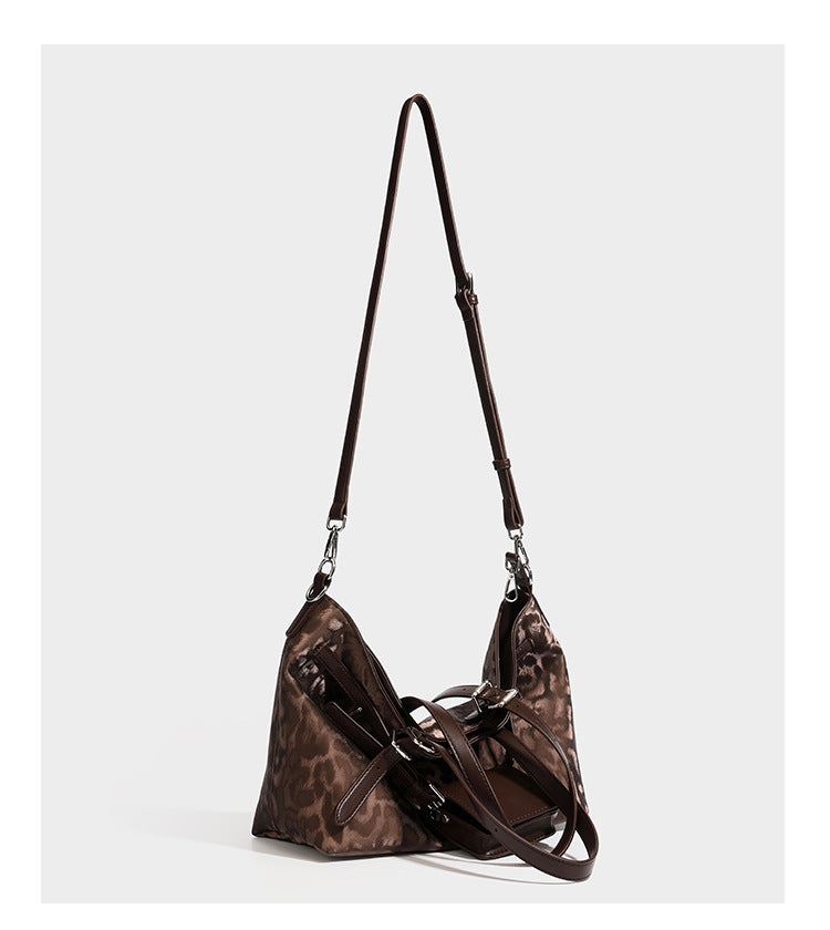 Glossy leopard-print tote bag with leather-look dark trim, dual top handles, detachable shoulder strap, and attached front