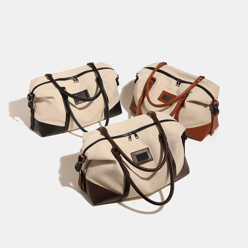 Large cream canvas tote bag with dark leather-look trim, dual top handles, and detachable shoulder strap, detail view 3