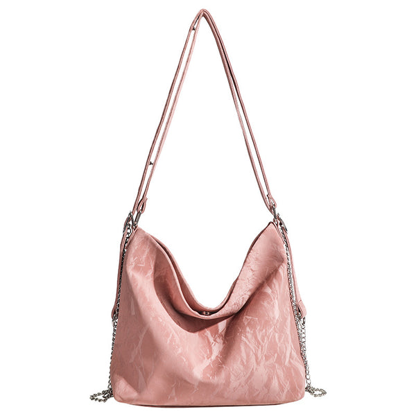 Blush pink slouchy hobo bag with crinkled sheen finish, silver-tone chain hardware, and adjustable shoulder strap, detail
